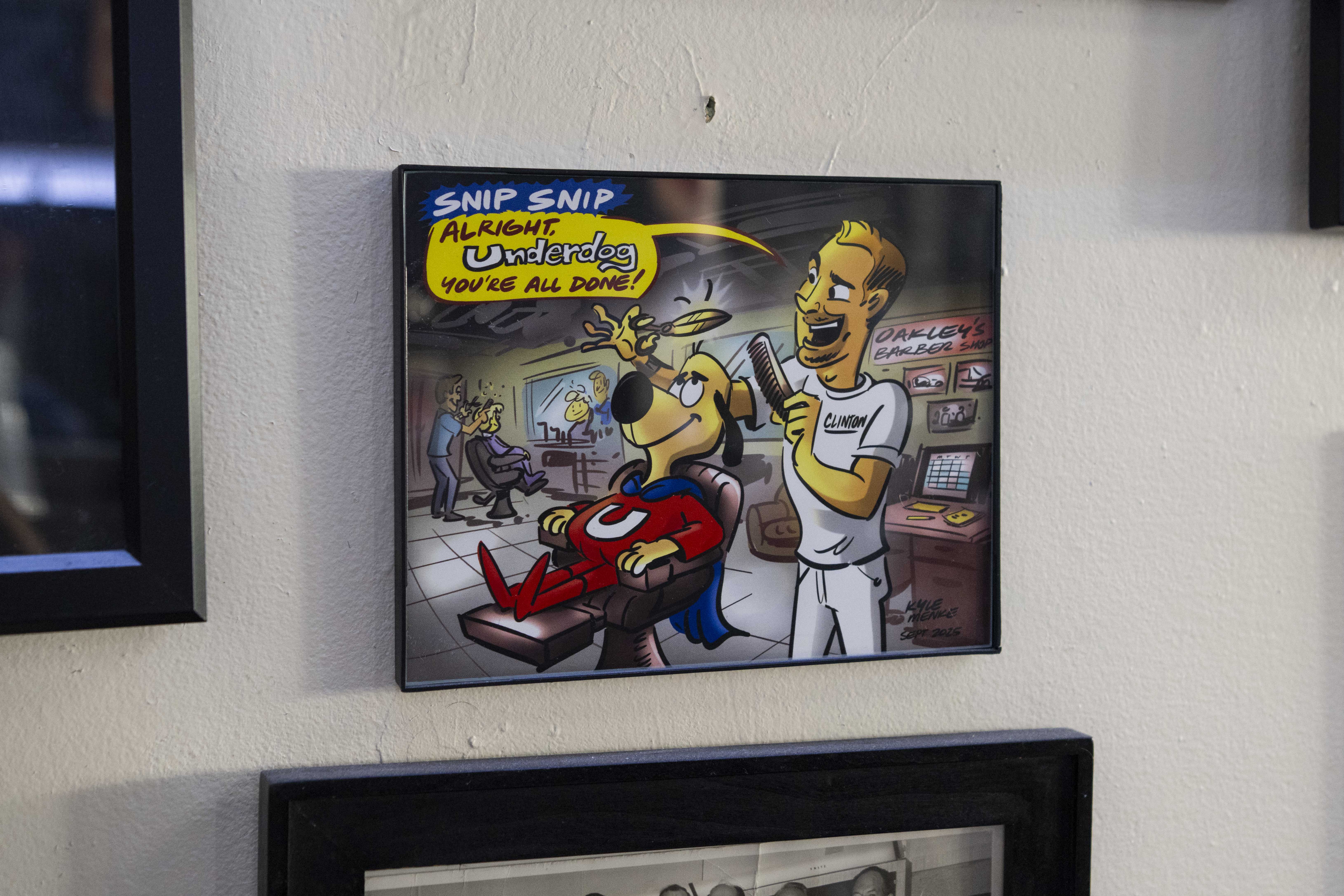 Picture of a framed cartoon on the wall of Oakley’s Barber Shop.